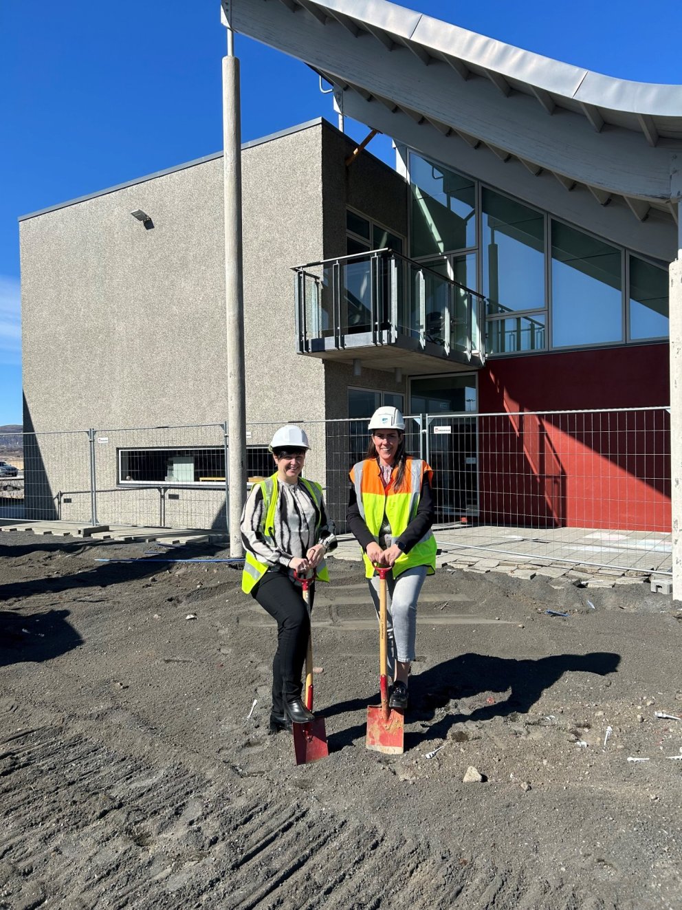 Ása Valdís oddviti og Iða Marsibil sveitarstjóri taka fyrstu skóflustungu að viðbyggingu við íþrótta…